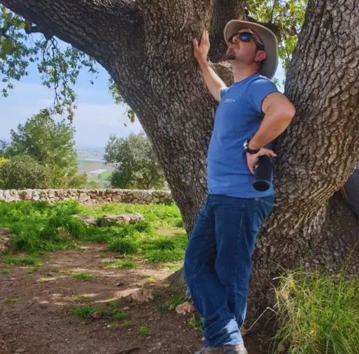 ליאור הרשקוביץ נשען על גזע אלון ומביט אל הצמרת